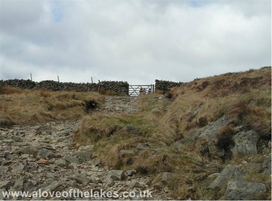 A love of the Lakes - At the top of the pass and through the gate and the terrain changes from stone to boggy grass
