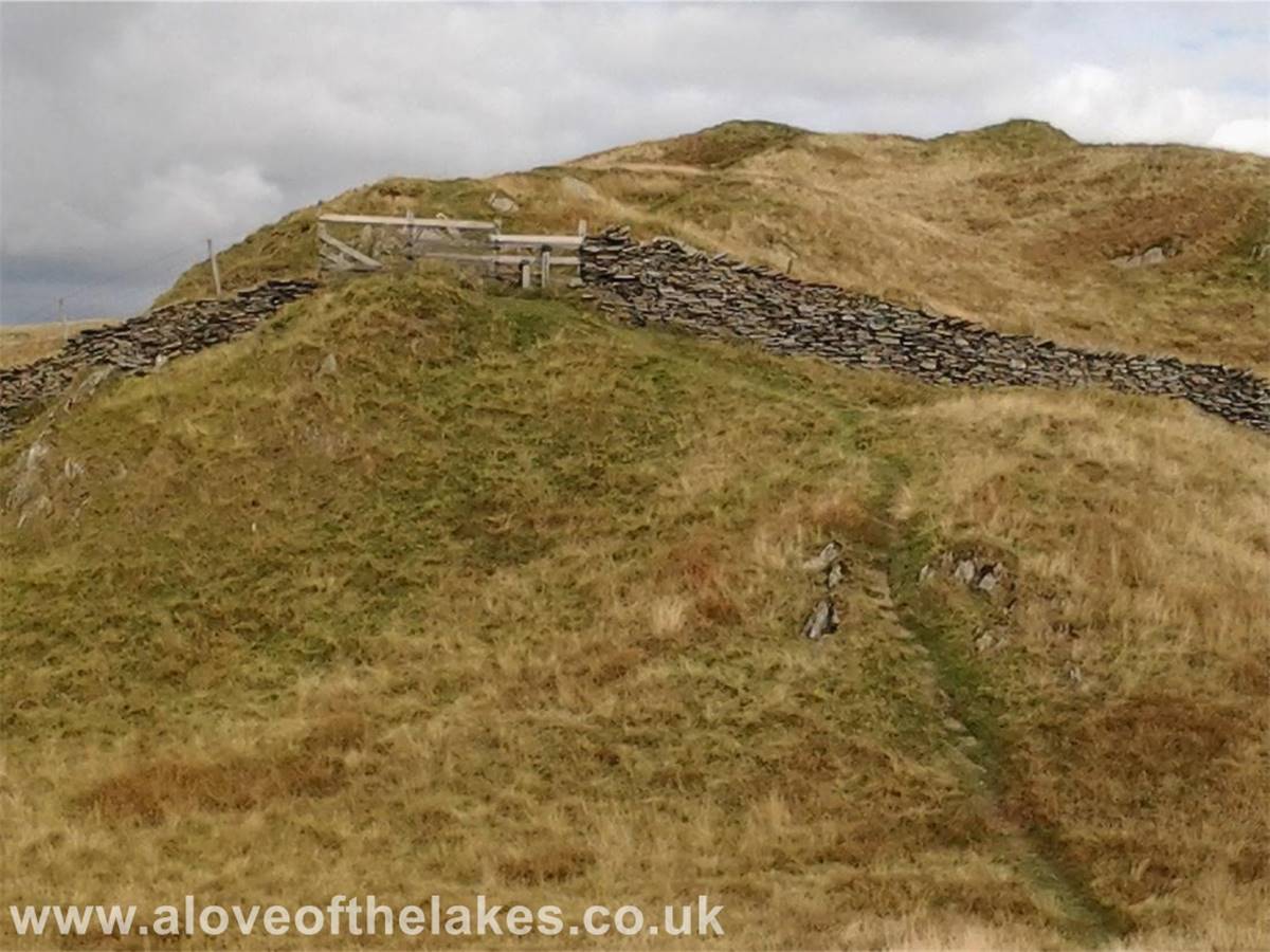 The stile in the wall leads on to the last part of the climb along the summit ridge
