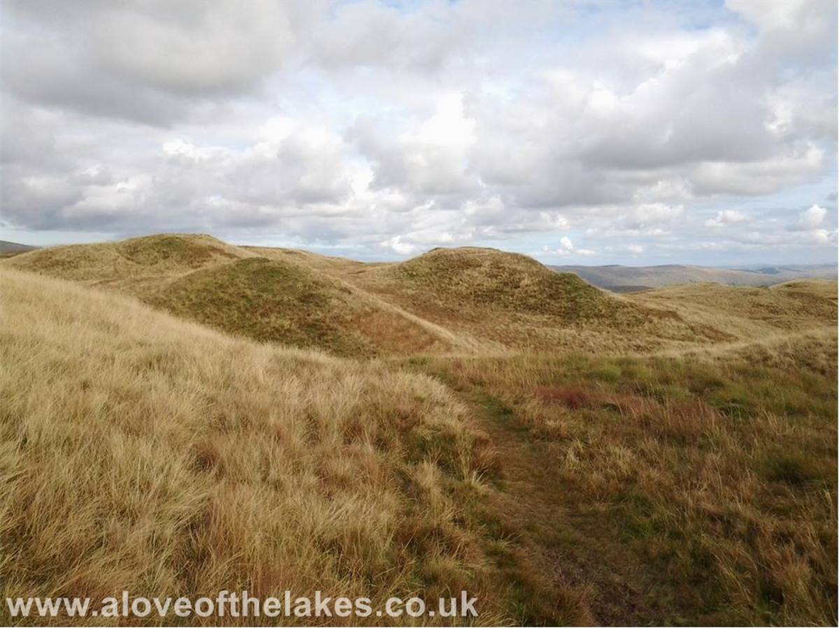 The ridge path winds its way around a number of grassy hillocks