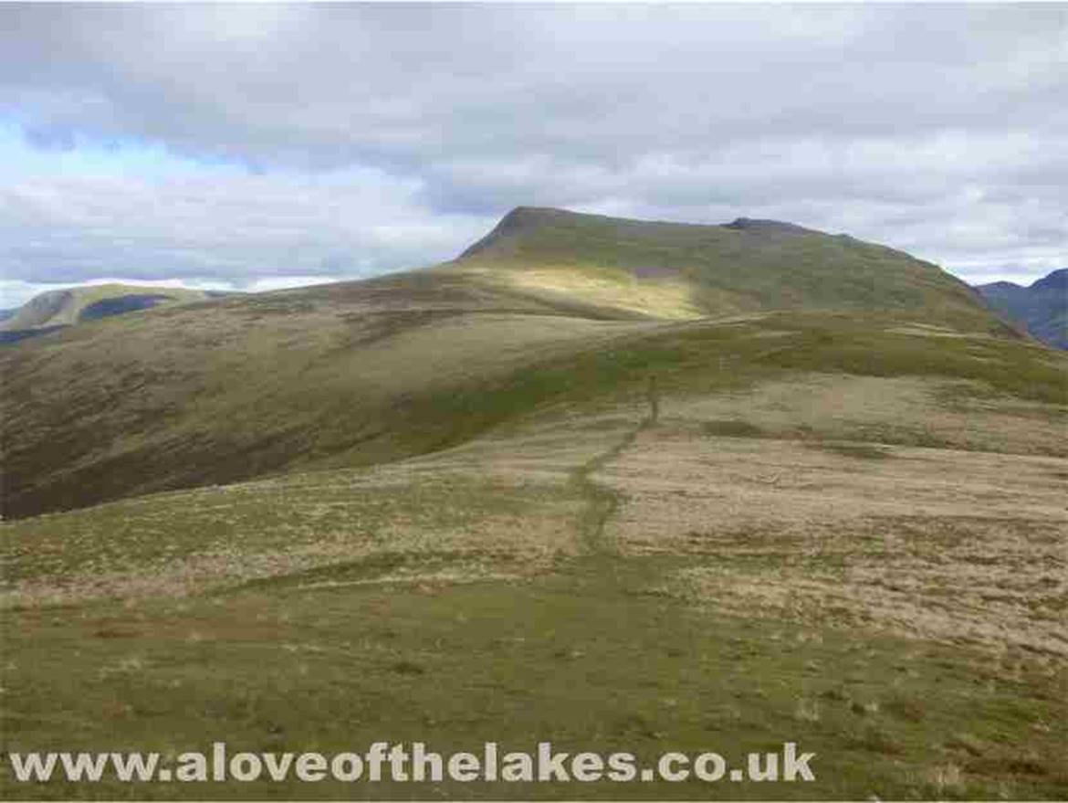 Looking south and the ridge walk to Starling Dodd, Red Pike and High Pike. What could possibly go wrong?? As we were
leaving the summit, Sue fell thigh deep into a pot hole on the wrong leg so to speak  causing the leg with the metal knee
joint to bend backwards in a way that it was not designed to. The scream was deafening and when turned round to see her 
lying in agony I seriously thought we would be coming down in a helicopter. Ten minutes later after the shock had subsided
she was able to carry on but at a much slower rate. It was only days later we discovered she had broke the Fibula
