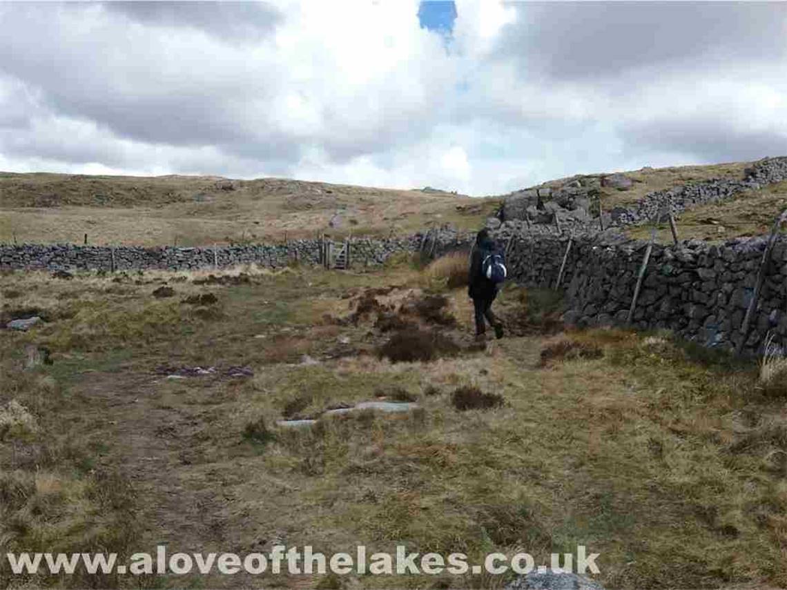 A gate through an intake wall leads to the summit of Irton Pike