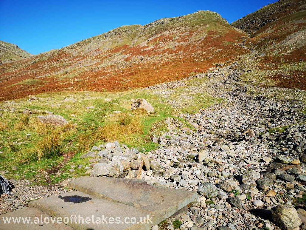The level path is followed up to the point just past Troughton Beck where some stone flags form a bridge
over the Beck. At this point make a right turn a follow a very sketch path initially that leads to the left of the
boulder field
