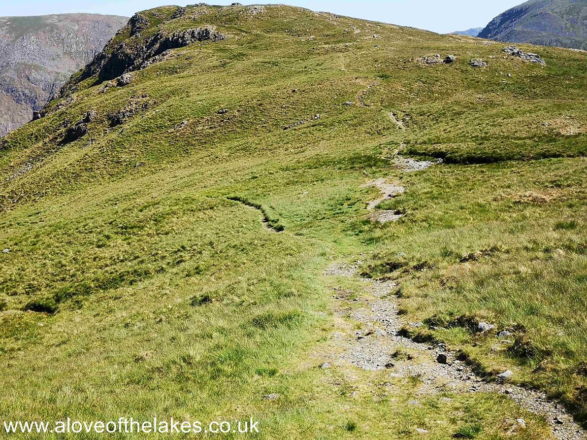 The side path lies roughly in the dip between the two tops (here seen branching left). This is for those walkers like us that would not feel safe descending Stirrup Crag